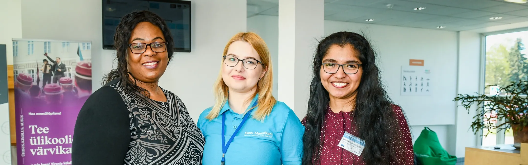 Kolm naist konverentsi registreerumislaua juures