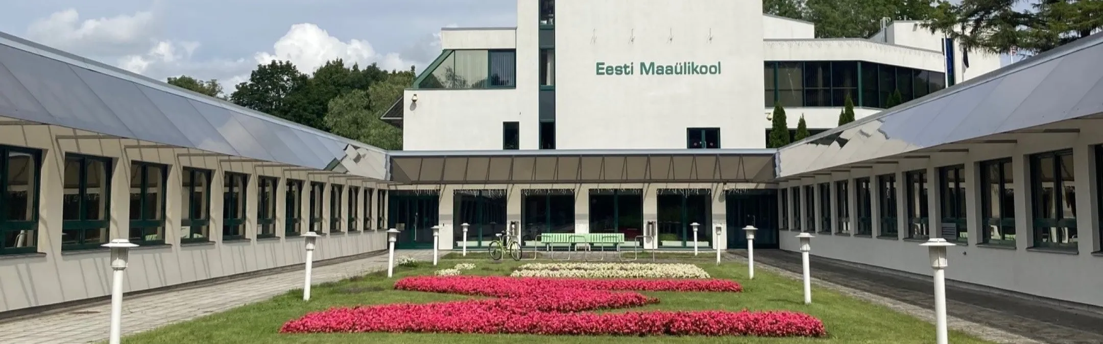 Suvine lillepeenar, mis asub kahe esileulatuva hoonetiiva vahel. 