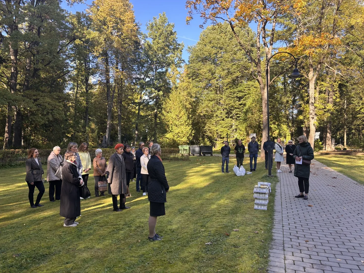 Inimesed seisavad õues, naine peab kõnet