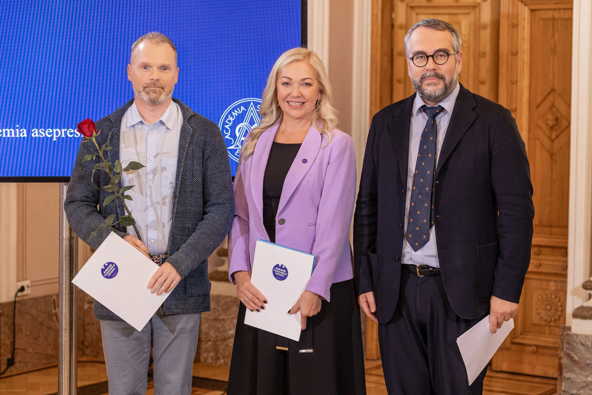 Kaks meest ja üks naine pidulikul vastuvõtul